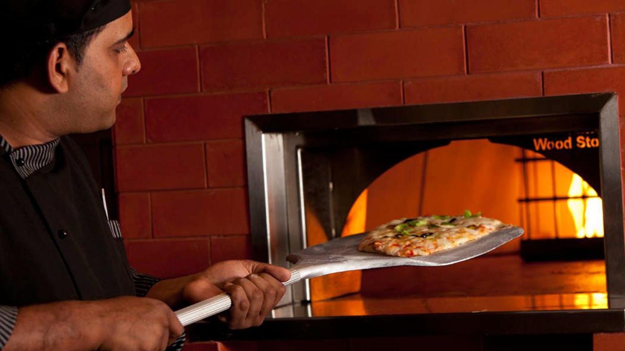 Holiday Inn Cochin By Ihg Kochi Exterior foto Pizza being removed from a wood-fired oven